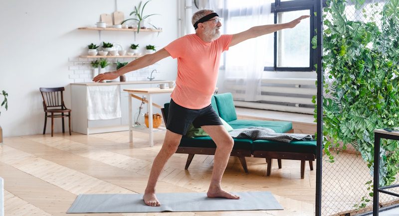 Senior man doing yoga - wellbeing and wellness
