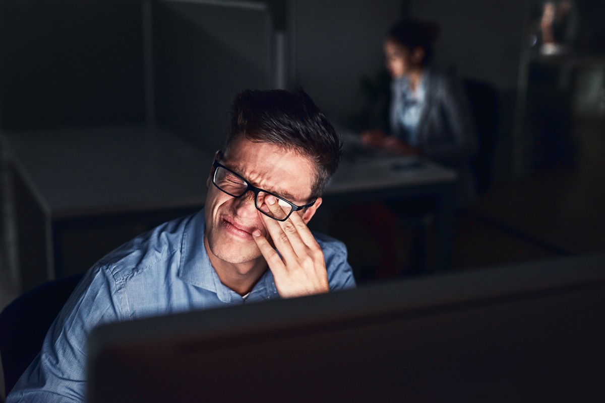 Shot of a young businessman working late at night in a modern office.